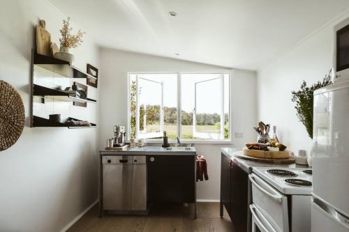 a kitchen with a sink and a stove and a window at Picturesque Barn located on the Shoalhaven River in Nowra