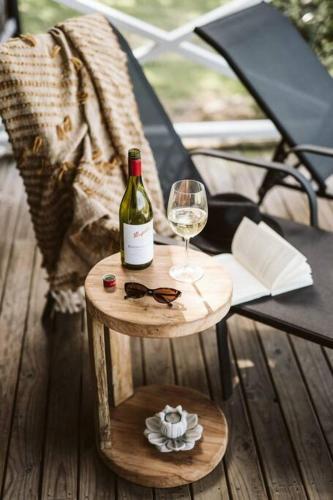 a bottle of wine and a glass on a table at Picturesque Barn located on the Shoalhaven River in Nowra
