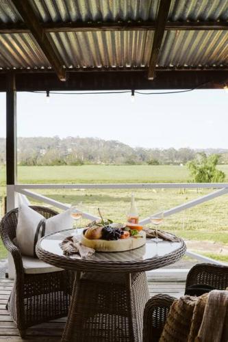 a table with a plate of food on a porch at Picturesque Barn located on the Shoalhaven River in Nowra