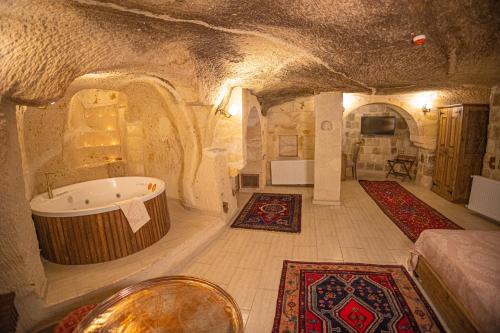 a large bathroom with a tub in a cave at Pietra Cave Suites in Ürgüp