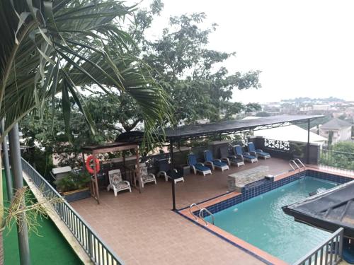 a swimming pool with chairs and a table at Koraf Hotels in Abuja