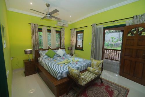 a bedroom with a bed and a chair and a window at Pension Michel Villa Roche Bois in La Digue