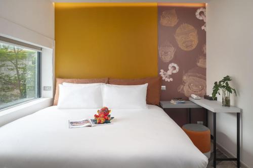 a bed with a book and a toy on it at Jono Bangkok Asok Hotel in Bangkok