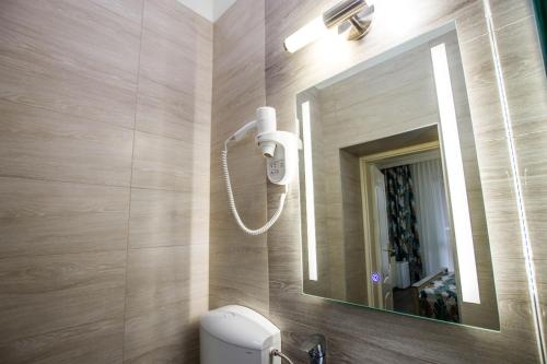 a bathroom with a sink and a mirror and a toilet at Járja Panzió in Hajdúszoboszló