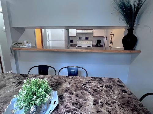 a dining room table with a kitchen in the background at Canadian Rockies Chalets by Trilink - 2 & 3 Bedroom Condos - Self Check-In - Walking Distance to Downtown - Free Parking - Pet-Friendly - No AC in Canmore
