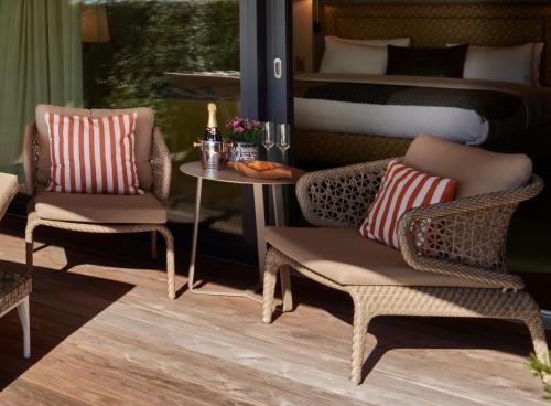 a bedroom with a bed and two chairs and a table at Strandhotel Schmerikon in Schmerikon