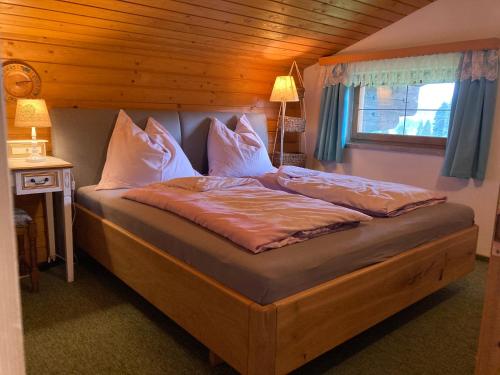 a large bed in a room with a window at Ellmauhof in Pfarrwerfen