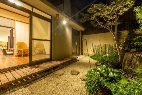 a house with a porch with a tree in the yard at Traditional house/200sqm/good location/5BR/15Max in Kinugasa