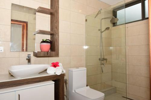 La salle de bains est pourvue d'une douche, d'un lavabo et de toilettes. dans l'établissement Residence Soleane, à Palmyre
