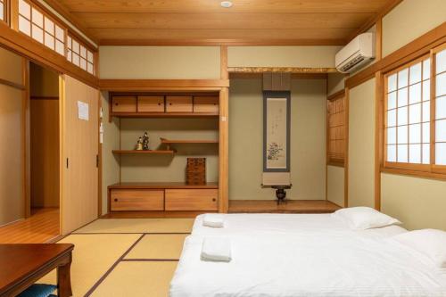 a bedroom with a large bed and a desk at Traditional house/200sqm/good location/5BR/15Max in Kinugasa