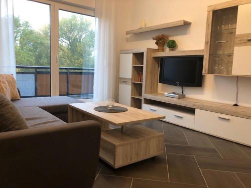 a living room with a couch and a tv and a table at Gästewohnung 6 in Oschersleben