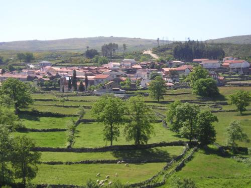 ein kleines Dorf auf einem grünen Feld mit Häusern in der Unterkunft Aldeia de Moura Morta 
