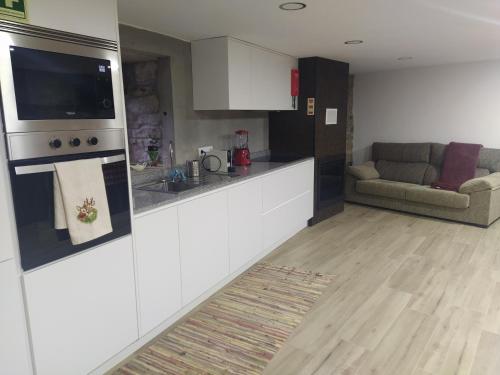 a kitchen with a counter and a couch in a room at Aldeia de Moura Morta in Moura Morta