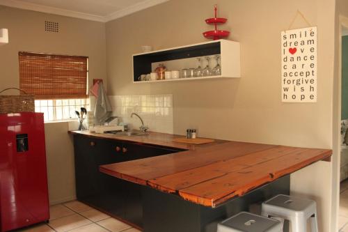 a kitchen with a wooden counter and a red refrigerator at Matroosbergstasie Karoohuisies in Matroosberg Private Nature Reserve