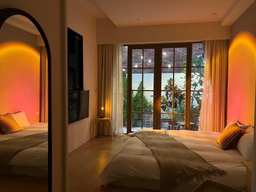 台南的住宿－荷米.輕新館(三館)，一间卧室设有两张床和大窗户