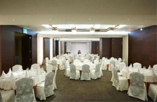 a banquet hall with white tables and chairs and a man at Niagara Hotel in Seoul