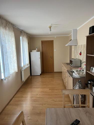a kitchen with a white refrigerator and a table at Atpūtas māja Sigulda in Sigulda