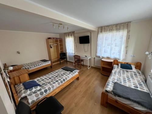 a room with three beds and a television in it at Atpūtas māja Sigulda in Sigulda