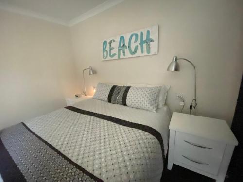 a bedroom with a bed and a sign on the wall at Middleton Bay Retreat in Albany