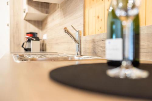a sink in a kitchen with a bottle of wine at Haus Amatschon in Brand