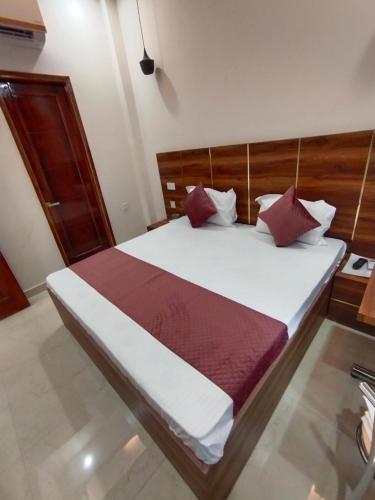 a bedroom with a large white bed with red pillows at Hotel kartik in Zirakpur