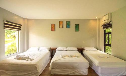 a bedroom with two beds and a window at RedDoorz @ Afamosa Villas Resort Ilocos Sur in Cabanglotan