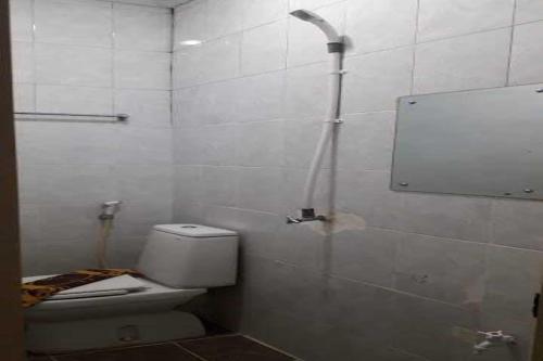 uma casa de banho branca com um WC e um chuveiro em EXPRESS O 91674 Penginapan Bm Prima em Duri