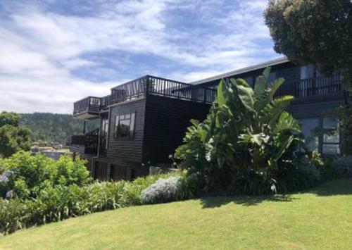 a house on a hill with a green yard at Ocean View in Herolds Bay