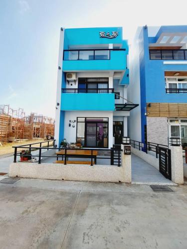 a blue building with benches in front of it at Summer Dream in Magong