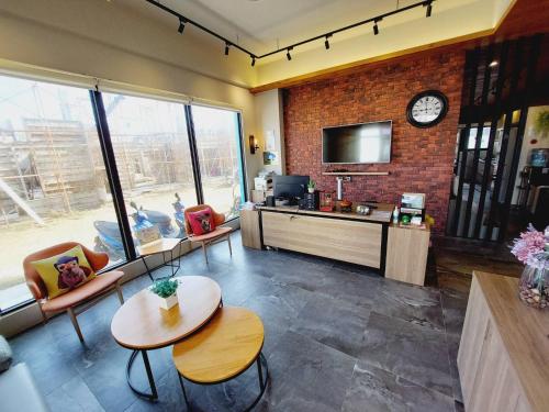 a living room with a clock on a brick wall at Summer Dream in Magong