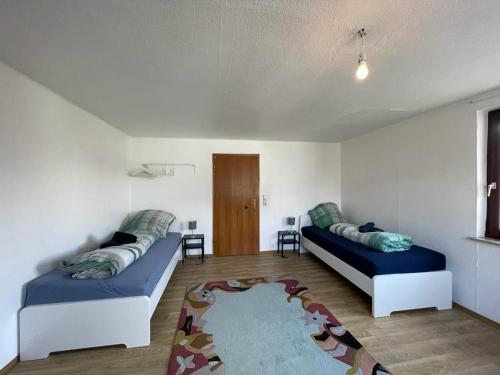 a living room with two beds and a rug at Worker Apartment Hohenstadt in Hohenstadt