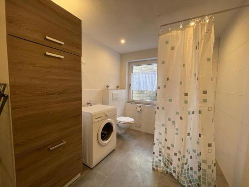 a bathroom with a washing machine and a toilet at Worker Apartment Hohenstadt in Hohenstadt