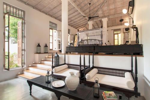 a living room with a table and a group of stairs at Haritha Villas & Spa in Hikkaduwa