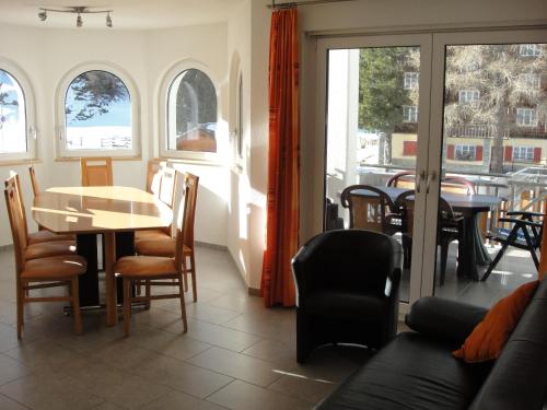a dining room with a table and chairs and windows at Haus Alpenstern in Saas-Grund