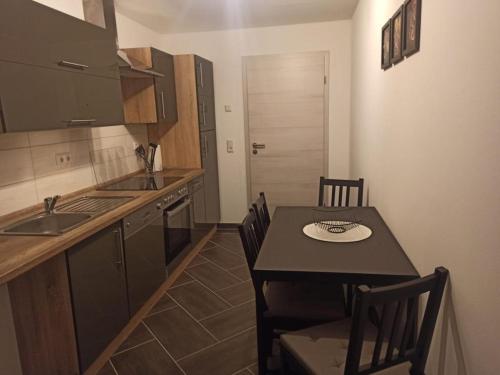 a kitchen with a table with chairs and a kitchen with a sink at Gästewohnung 5 in Oschersleben