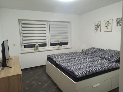 een slaapkamer met een bed en een raam bij Gästewohnung 5 in Oschersleben