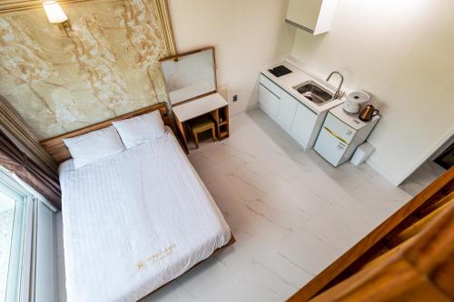 a small room with a bed and a sink at Aewol Oceanstay in Jeju