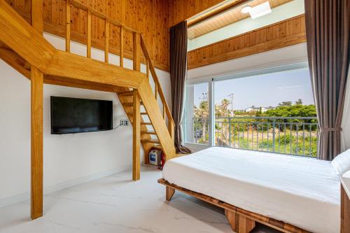 a bedroom with a bunk bed and a large window at Aewol Oceanstay in Jeju