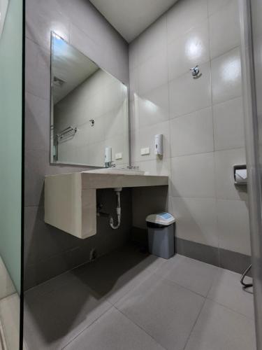 uma casa de banho com um lavatório e um espelho em Benrose Hotel em Cagayan de Oro