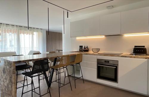 une cuisine avec des placards blancs et un îlot avec des tabourets de bar dans l'établissement My St-Tropez, à Saint-Tropez