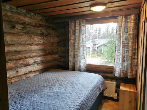 1 dormitorio en una cabaña de madera con cama y ventana en Soppela en Syöte