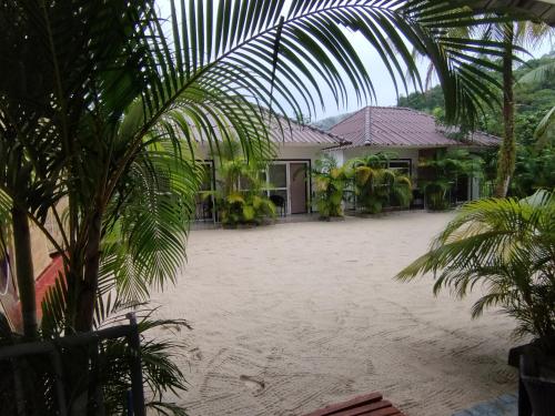 a house with a large courtyard with palm trees at WHITE SAND ARK RESORT in Koh Rong Island