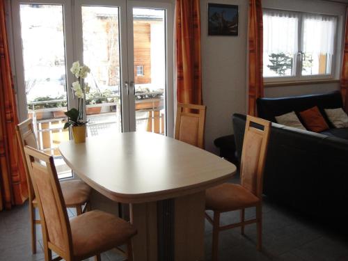 a living room with a table and chairs and a couch at Haus Alpenstern in Saas-Grund