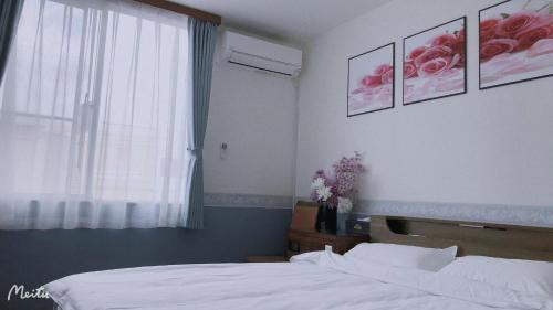 a bedroom with a bed and a window with roses on the wall at ホテルルネサンス土浦 in Tsuchiura