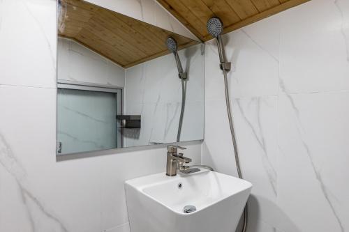 a bathroom with a sink and a mirror at Aewol Oceanstay in Jeju