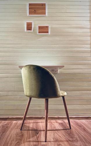 a green chair sitting in front of a wall at Karczma Leśniczanka in Wielbark