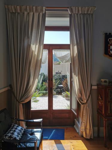 a living room with a sliding glass door and a chair at Chalet Vitorino in Sintra