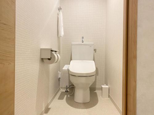 a bathroom with a white toilet in a stall at Takanobashi HOTEL in Hiroshima