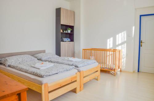 sypialnia z 2 łóżkami pojedynczymi i łóżeczkiem dziecięcym w obiekcie Apartmán Kampelička w mieście Rataje nad Sázavou