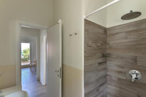 a bathroom with a shower with wooden walls at Il Quartiere apt Giglio in Pomonte